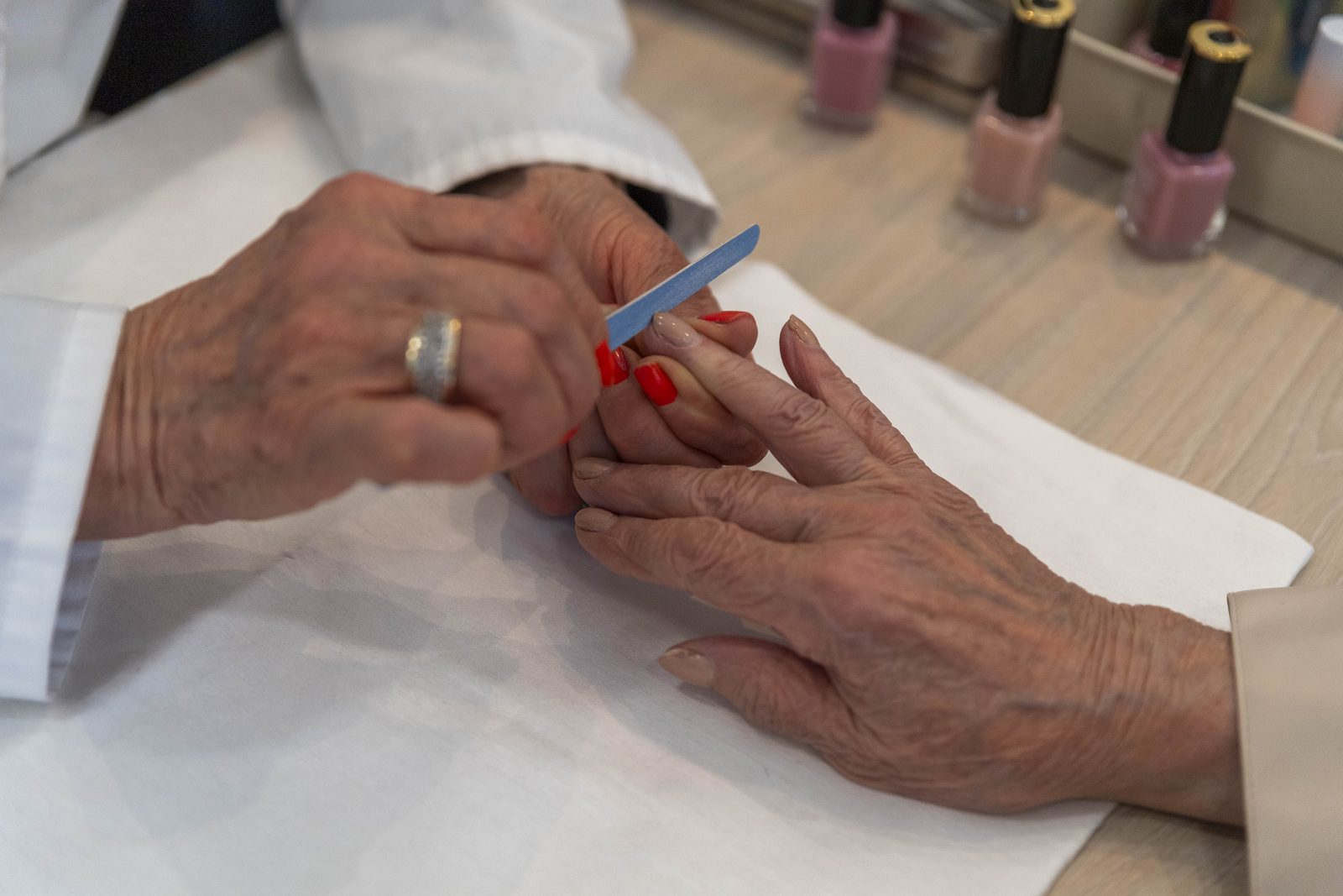 Residente recibiendo manicure con lima de uñas