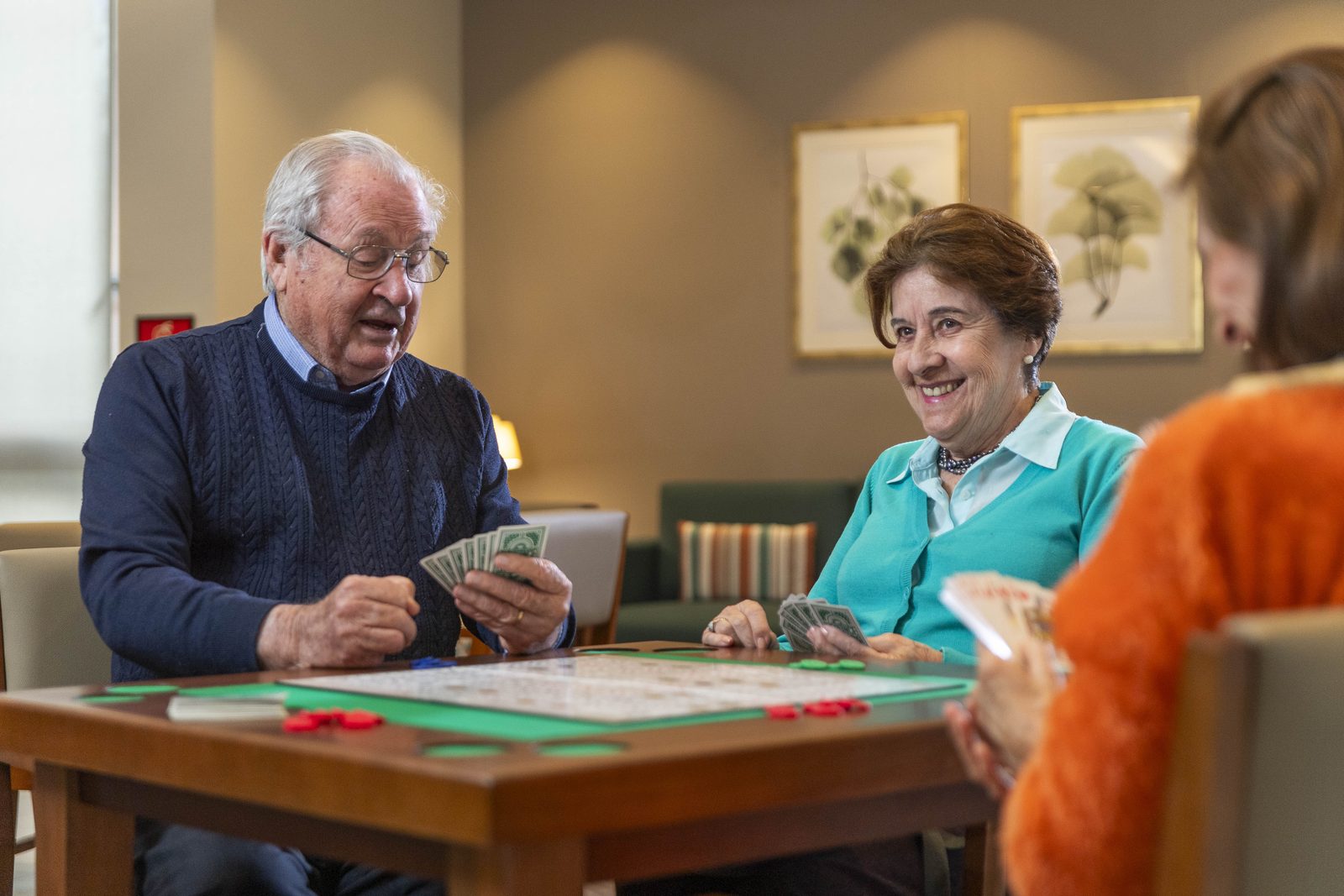 Residentes jugando cartas en la sala de juegos de Senior Suites